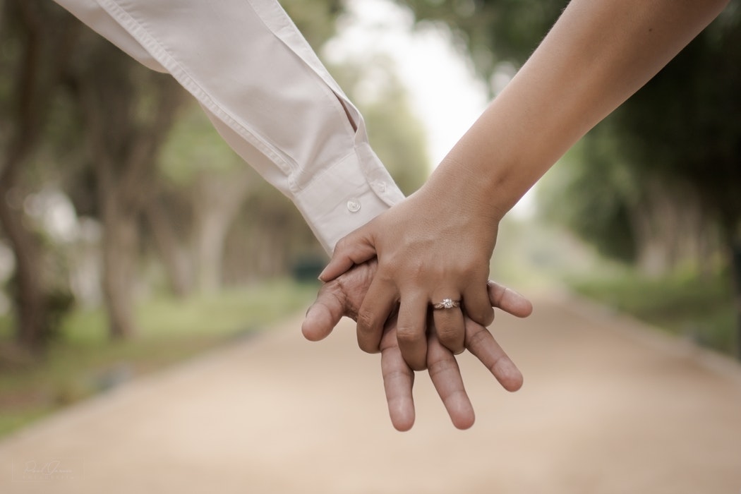 Couple holding hands walking in the park