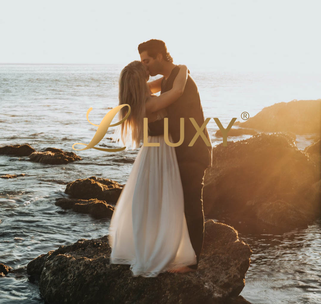Couple kissing by the ocean at sunset